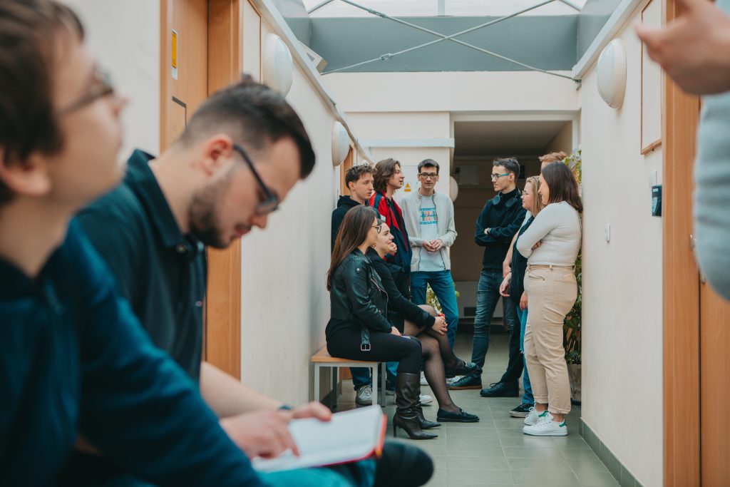 student czytający książkę, siedzi na korytarzu